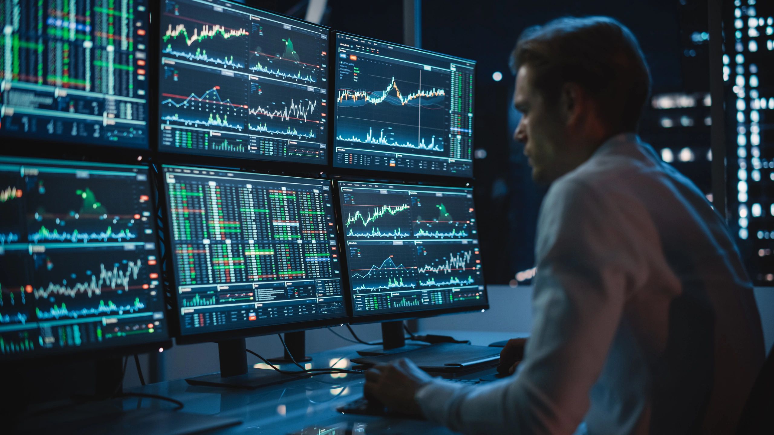 Trader at multiple screens on trading floor